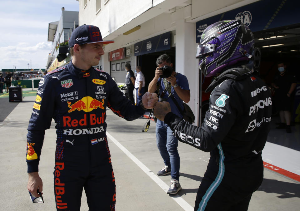 Mercedes driver Lewis Hamilton of Britain, right, after setting a pole position fist bumps with third placed Red Bull driver Max Verstappen of the Netherlands after the qualifying session for the Hungarian Formula One Grand Prix, at the Hungaroring racetrack in Mogyorod, Hungary, Saturday, July 31, 2021. The Hungarian Formula One Grand Prix will be held on Sunday. (David W Cerny/Pool via AP)