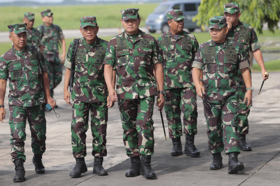 Indonesian Armed Forces Chief Adm. Yudo Margono, center, walks with his staff at Juanda Air Base in Surabaya, East Java, Indonesia, Tuesday, April 18, 2023. Indonesia's military chief on Tuesday dismissed a separatist group claim that they had killed more than a dozen government soldiers who were searching for a New Zealand pilot taken hostage by the rebels in the restive Papua region. (AP Photo/Trisnadi)