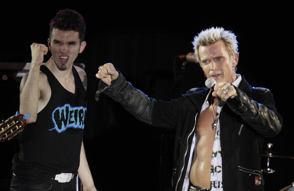 Billy Idol, right, is joined on stage by Michael Henrichsen, left, as Idol performs Friday, Oct. 26, 2012, in Seattle. Idol came to play in Seattle after Henrichsen launched a two-year grass-roots campaign to convince the rock star to play for his birthday party. (AP Photo/Ted S. Warren)