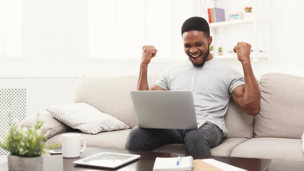  Happy man with laptop on his lap 