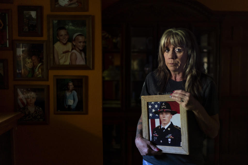 Barbie Rohde holds a photo of her son, Army Sgt. Cody Bowman, at her home Sunday, June 11, 2023, in Flint, Texas. Rohde runs the most active chapter of a nonprofit called Mission 22, focused on ending the scourge of military and veteran suicide, which kills thousands every year, at a rate far higher than the general population. Three-quarters of those who take their own lives use guns. One of them was her 25-year-old son. (AP Photo/David Goldman)