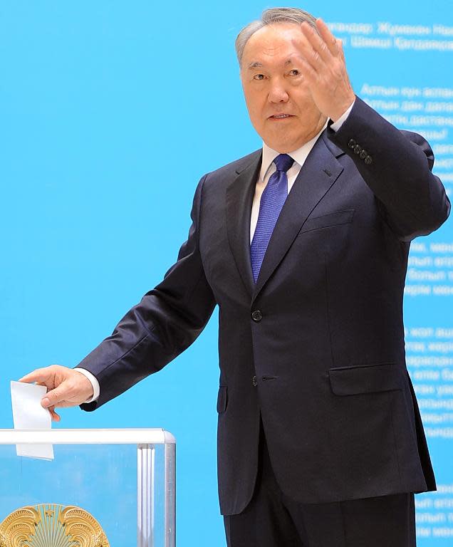 Kazakh President Nursultan Nazarbayev gestures as he casts his ballot at a polling station in the capital Astana on April 26, 2015