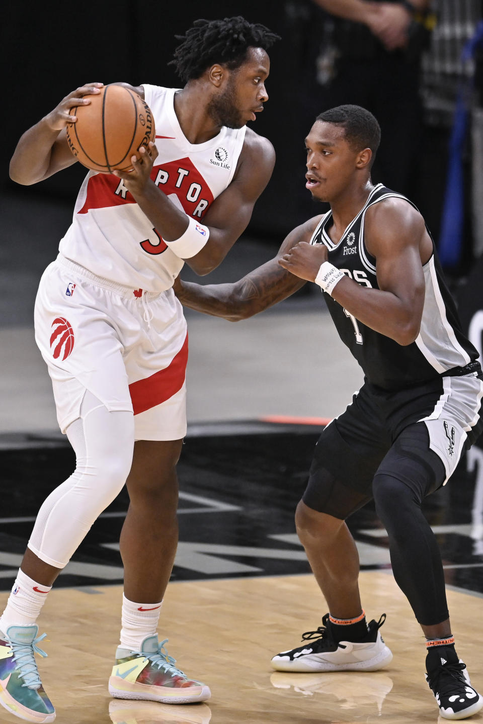 Toronto Raptors' O.G. Anunoby, left, drives against San Antonio Spurs' Lonnie Walker IV during the first half of an NBA basketball game Saturday, Dec. 26, 2020, in San Antonio. (AP Photo/Darren Abate)