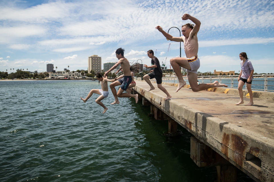 MELBOURNE, AUSTRALIA - JANUARY 11: Young people jump off St Kilda Pier on January 11, 2021 in Melbourne, Australia. Melbourne is forecast to record its hottest day in a year with temperatures expected to reach 38 degrees Celsius. (Photo by Darrian Traynor/Getty Images)