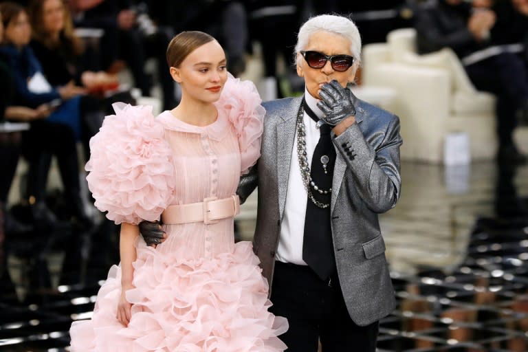German fashion designer Karl Lagerfeld (R) salutes the audience with actress Lily-Rose Depp at the end of the Chanel spring/summer Haute Couture collection on January 24, 2017