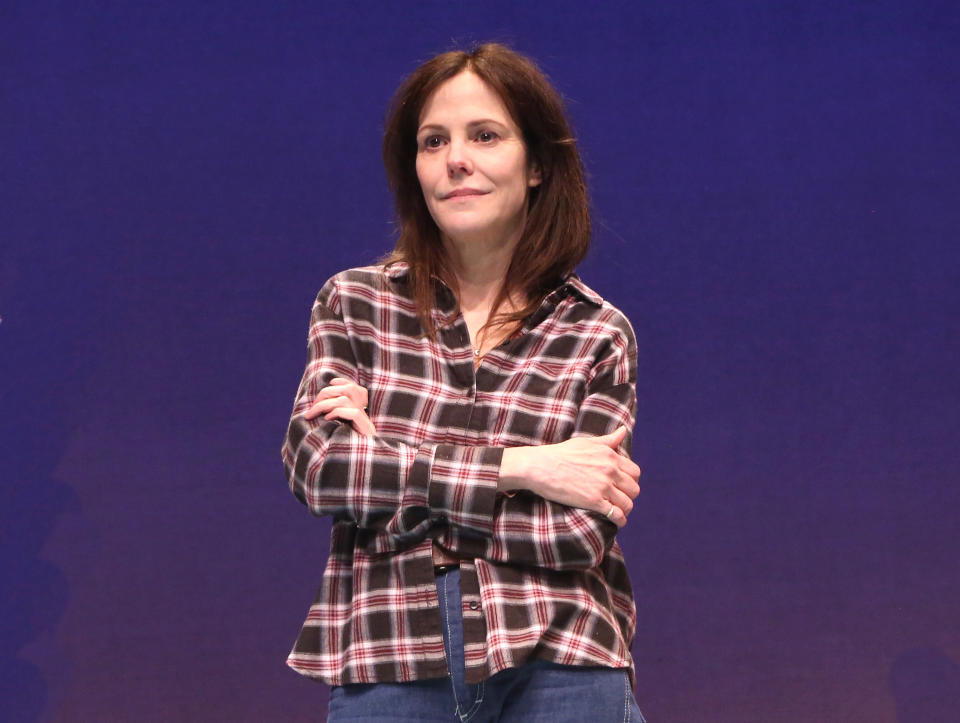 Mary-Louise Parker stands alone and hugs herself