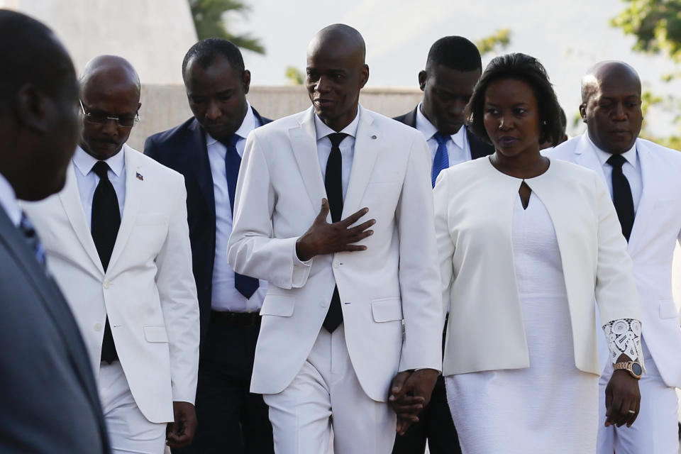 FILE - In this Oct. 17, 2019 file photo, President Jovenel Moïse, center, walks with his wife Martine, after laying flowers to mark the death anniversary of revolutionary leader Jean-Jacques Dessalines, in Port-au-Prince, Haiti. Moïse said during a radio interview on Monday, Oct. 28, 2019, that he has asked the U.S. government for humanitarian assistance as protesters demanding his resignation took to the streets in the seventh week of demonstrations that have shuttered many schools and businesses across the country. (AP Photo/Rebecca Blackwell, File)