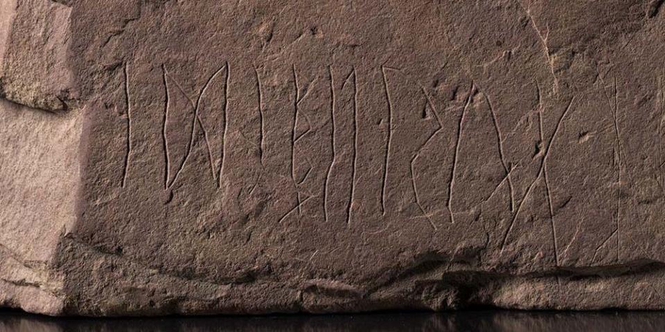 A close up of the stone show a word clearly carved into the rock.