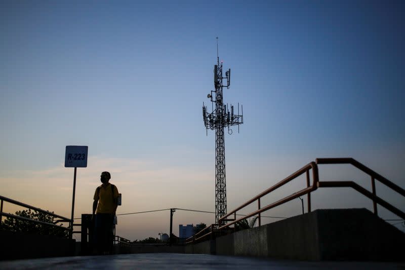 A man walks by near a cellular tower in the municipality of Guadalupe