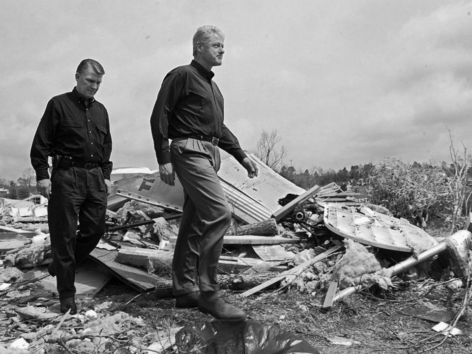 US President Bill Clinton, (R), with FEMA Director James Lee Witt, (L), tour a neighborhood hit by the tornado in Birmingham, AL, April 1998.