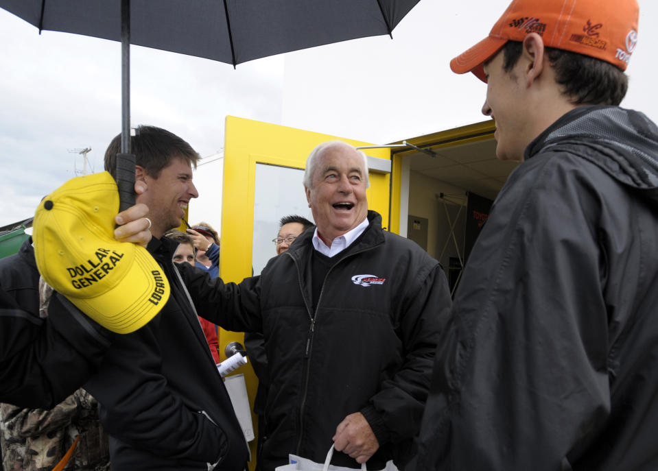 Car owner Roger Penske, center, chats with drivers Denny Hamlin, left, and Joey Logano in the garage area prior to the NASCAR Daytona 500 Sprint Cup series auto race at Daytona International Speedway in Daytona Beach, Fla., Sunday, Feb. 26, 2012. (AP Photo/Phelan M. Ebenhack)