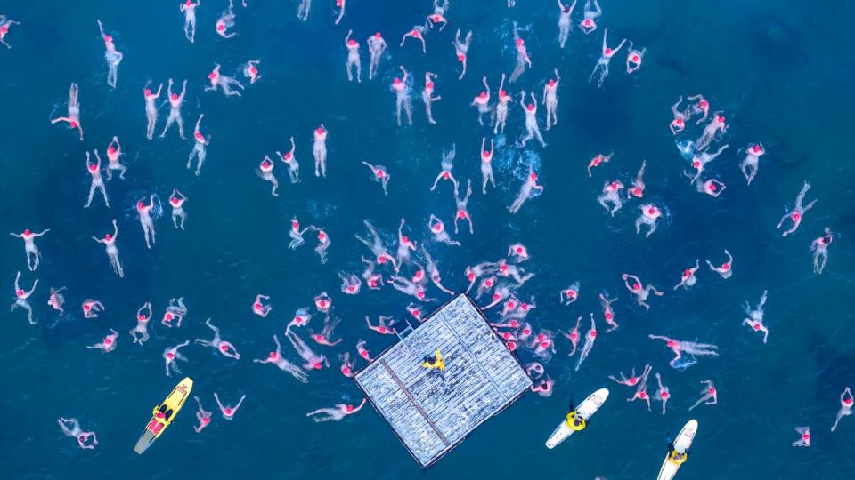 Nacktschwimmer von oben. Die Dronenaufnahme zeigt einige der Schwimmer und Rettungskräfte im eiskalten Wasser.  (Bild: Rob Blakers/ AAP/ dpa)