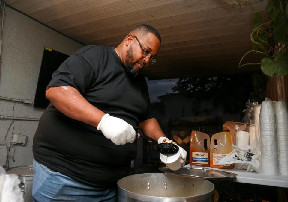 Larry D Reaves, de 53 años, dueño de World's Famous Souseman BBQ, sirve una taza de su famoso souse de cerdo en el patio trasero de su casa de Opa-locka, Florida, el 19 de noviembre de 2022.
