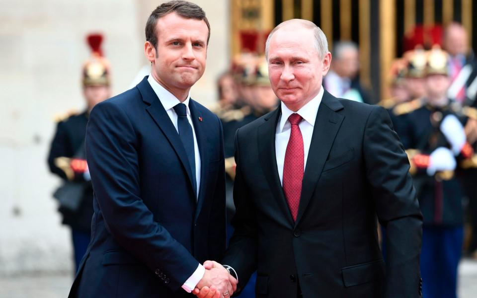 Russian President Vladimir Putin is welcomed by French President Emmanuel Macron - Credit: STEPHANE DE SAKUTIN/AFP