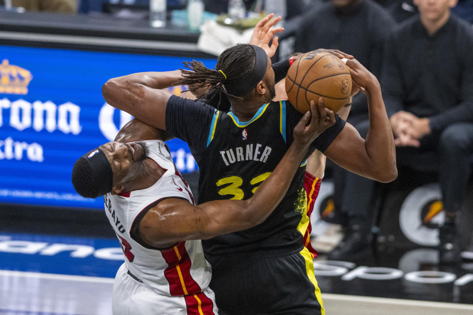 Miami Heat center Bam Adebayo (13) reacts as he makes contact with Indiana Pacers center Myles Turner (33) while attempting to make a steal during the second half of an NBA basketball game in Indianapolis, Sunday, April 7, 2024. (AP Photo/Doug McSchooler)