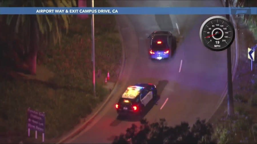 The driver enters the John Wayne Airport in Santa Ana as an officer follows closely behind on May 24, 2024. (KTLA)