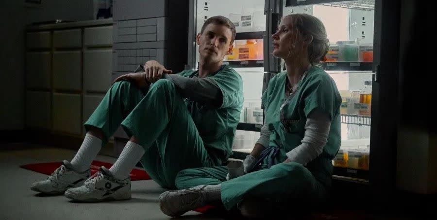 two nurses talking while sitting on the ground of a lab