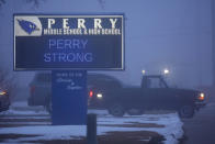 Parents drop students off at Perry Middle School, Thursday, Jan. 25, 2024, in Perry, Iowa. Middle school students returned to classes Thursday for the first time since a high school student opened fire in a shared cafeteria, killing two people and injuring six others. (AP Photo/Charlie Neibergall)