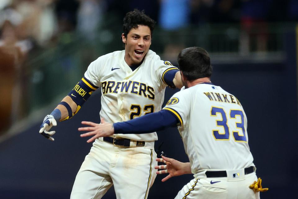 Christian Yelich celebrates a walk off RBI single with Jesse Winker (33) to defeat the Cincinnati Reds during the ninth inning at American Family Field on July 24, 2023.