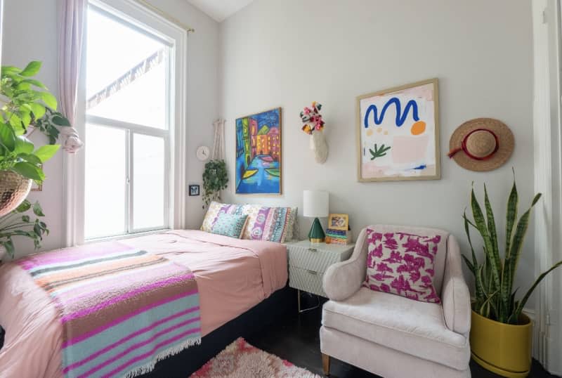 White bedroom with pink decor and textile accents