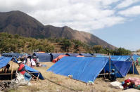 Makeshift tents are erected to be used as a temporary shelter for those affected by an earthquake in Sembalun, Lombok Island, Indonesia, Monday, Aug. 6, 2018. The powerful earthquake struck the Indonesian tourist island of Lombok, killing a number of people and shaking neighboring Bali, as authorities on Monday said thousands of houses were damaged and the death toll could climb. (AP Photo/Adrial Pranandi)