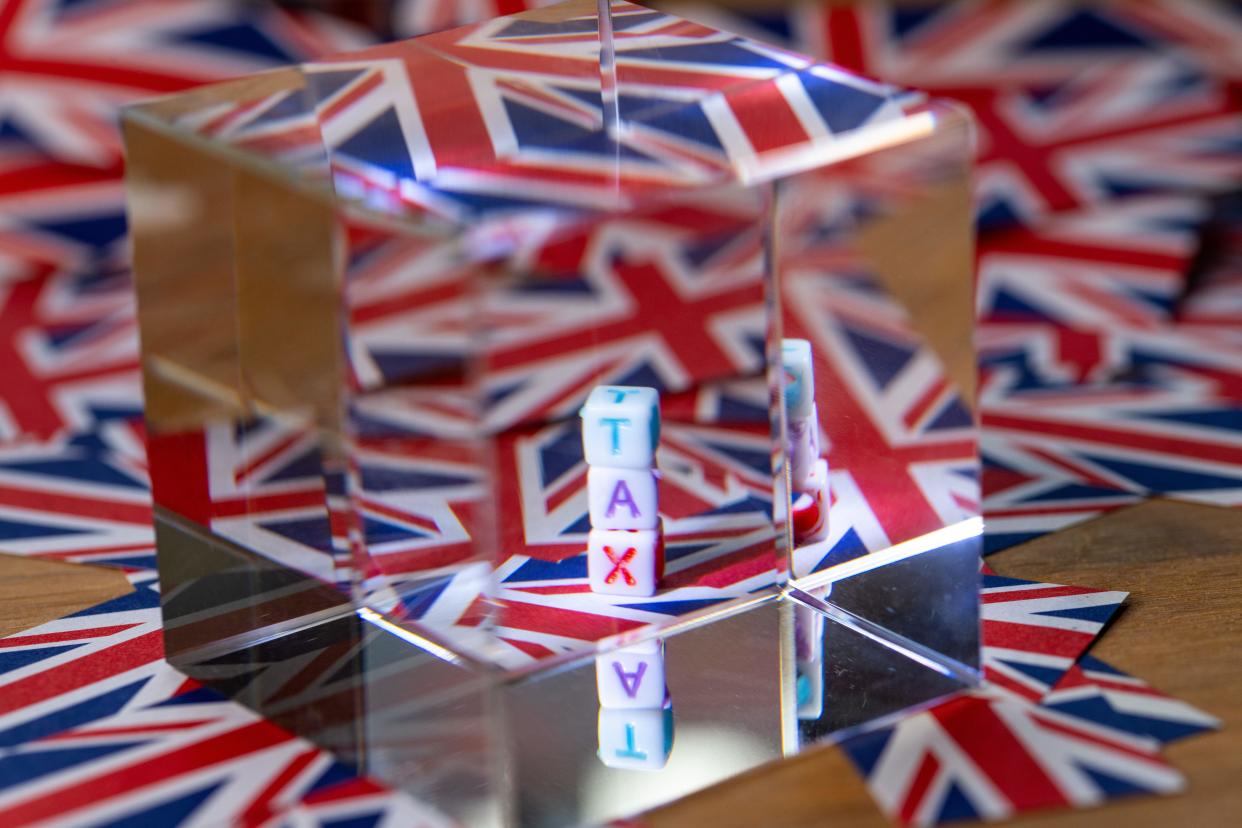 A crystal cube next to block letters spelling out TAX, future of Tax, with the background of the Union Jack flag, UK Tax, United Kingdom taxation