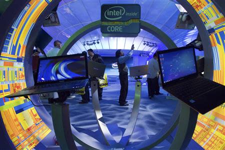 Gopi Sirineni (C) of San Jose, California takes a video of the Intel booth during the 2012 International Consumer Electronics Show (CES) in Las Vegas, Nevada, in this January 12, 2012 file photo. REUTERS/Steve Marcus/Files