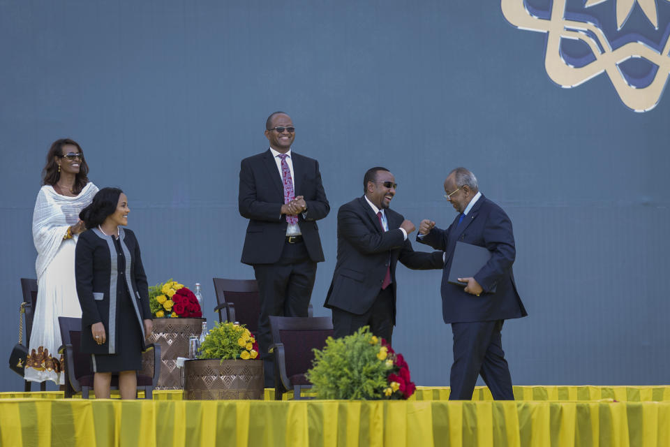 Ethiopia's Prime Minister Abiy Ahmed, center, greets Djibouti's President Ismail Omar Guelleh, right, as First Lady Zinash Tayachew, left, looks on at Abiy's inauguration ceremony after he was sworn in for a second five-year term, in the capital Addis Ababa, Ethiopia Monday, Oct. 4, 2021. Abiy was sworn in Monday for a second five-year term running a country in the grip of a nearly year-long war, as a handful of visiting African leaders urged him to hold the nation together. (AP Photo/Mulugeta Ayene)