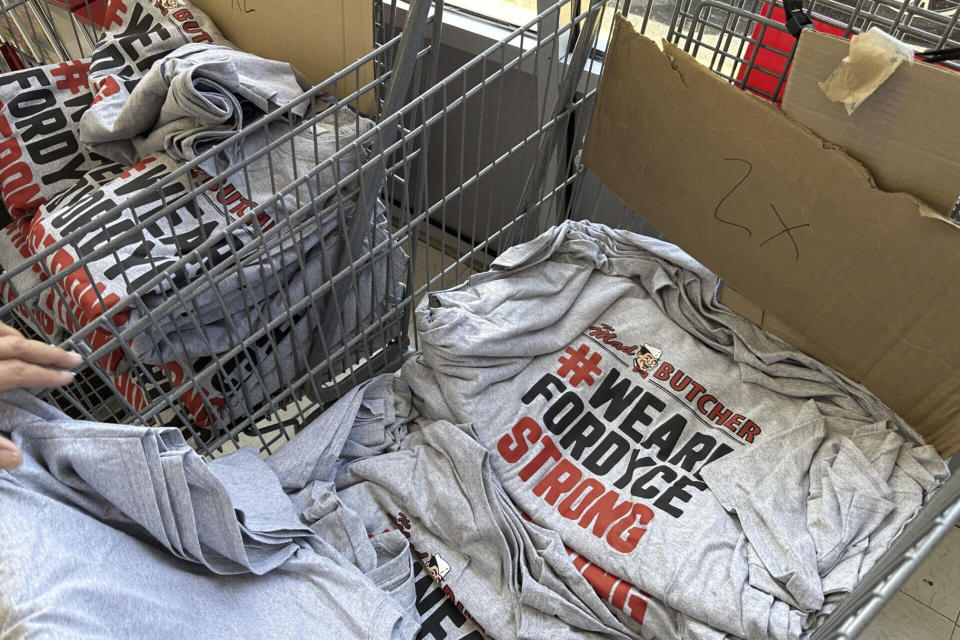 A stack of shirts being handed out to customers sits in a shopping cart at the Mad Butcher grocery store in Fordyce, Ark., Tuesday, July 2, 2024. The grocery store reopened on Tuesday, 11 days after a shooter killed four people and injured 10 others in in the store and its parking lot. (AP Photo/Andrew DeMillo)