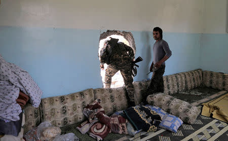 A member of the Syrian Democratic Forces moves from house to house to hide from Islamic State's sniper in the old city of Raqqa. REUTERS/Zohra Bensemra