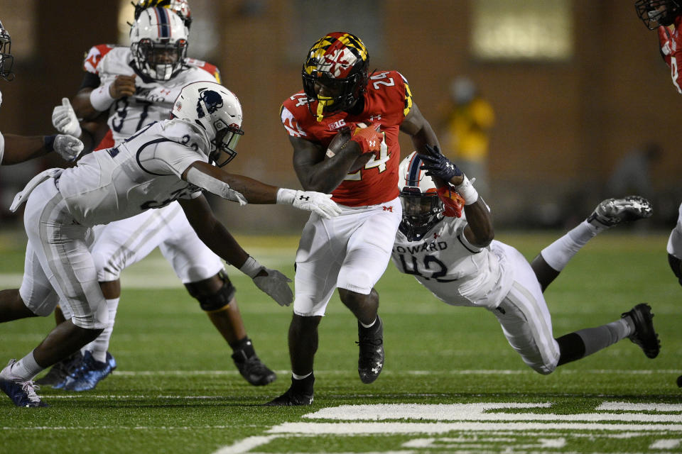 Maryland running back Roman Hemby, center, runs with the ball against Howard defensive lineman Marcus Brown (42) and linebacker Terrence Hollon, front left, during the second half of an NCAA college football game, Saturday, Sept. 11, 2021, in College Park, Md. (AP Photo/Nick Wass)