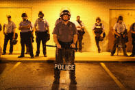 <p>Police stand guard before the mandatory midnight curfew on August 16, 2014 in Ferguson, Missouri. The curfew was imposed on Saturday in an attempt to reign in the violence that has erupted nearly every night in the suburban St. Louis town since the shooting death of teenager Michael Brown by a Ferguson police officer on August 9. (Scott Olson/Getty Images) </p>