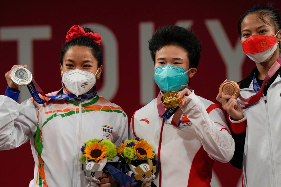 <div class="paragraphs"><p>Silver medalist India's Mirabai Chanu(L) with Gold medalist China's Hou Zhihui (M) and bronze medal winner AISAH Windy Cantika poses for photographs during the presentation ceremony of women's 49 kg category weightlifting event at the Summer Olympics 2020, in Tokyo, Saturday, July 24, 2021.</p></div>