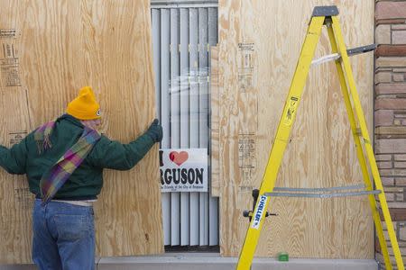 Volunteer, Paul Morris boards up windows at the "I Love Ferguson" headquarters in preparation for the grand jury verdict in the shooting death of Michael Brown in Ferguson, Missouri, November 18, 2014. REUTERS/Kate Munsch