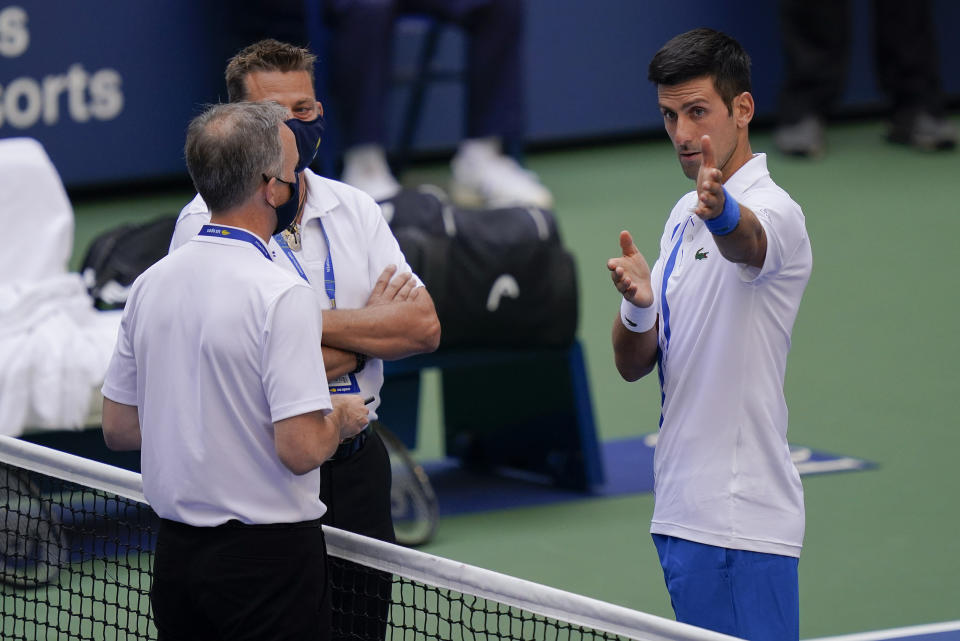 Novak Djokovic discute con los supervisores tras propinarle un pelotazo a la jueza de línea durante el partido de octavos de final del Abierto de Estados Unidos ante Pablo Carreño, el domingo 6 de septiembre de 2020, en Nueva York. Djokovic fue descalificado. (AP Foto/Seth Wenig)