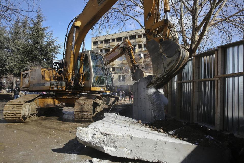 Bulldozers tear down a concrete wall erected in the northern city of Mitrovica on Sunday, Jan. 5, 2017, that has provoked tensions between Kosovo and neighboring Serbia. The wall removal followed an agreement between the government with the country's ethnic Serb minority, facilitated by the European Union and the United States embassy . (AP Photo/Visar Kryeziu)