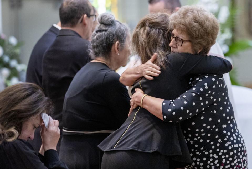 People hugging at Ernest Z. Robles' funeral