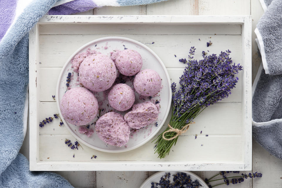 Handmade lavender bath bombs and lavender flowers in white tray, top view