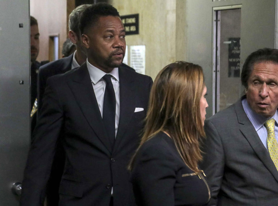 Cuba Gooding Jr., left, follows his legal team from court after he pleaded not guilty to sexual misconduct charges, Tuesday Oct. 15, 2019, in New York. The new charge involves an alleged incident in October 2018. The defense paints it as a shakedown attempt. (AP Photo/Bebeto Matthews)