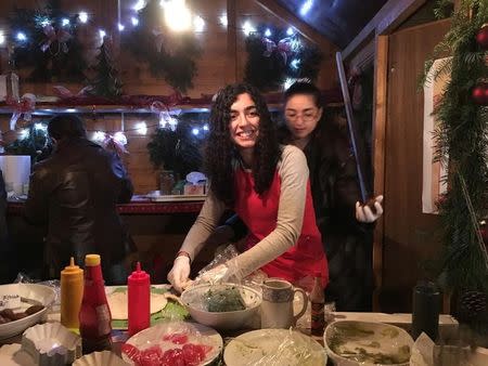Syrian refugees Mayar (L) and Nawar Ballish make falafel sandwiches at a German Christmas market in Schillingsfuerst, Germany, November 25, 2016. REUTERS/Michelle Martin/Files