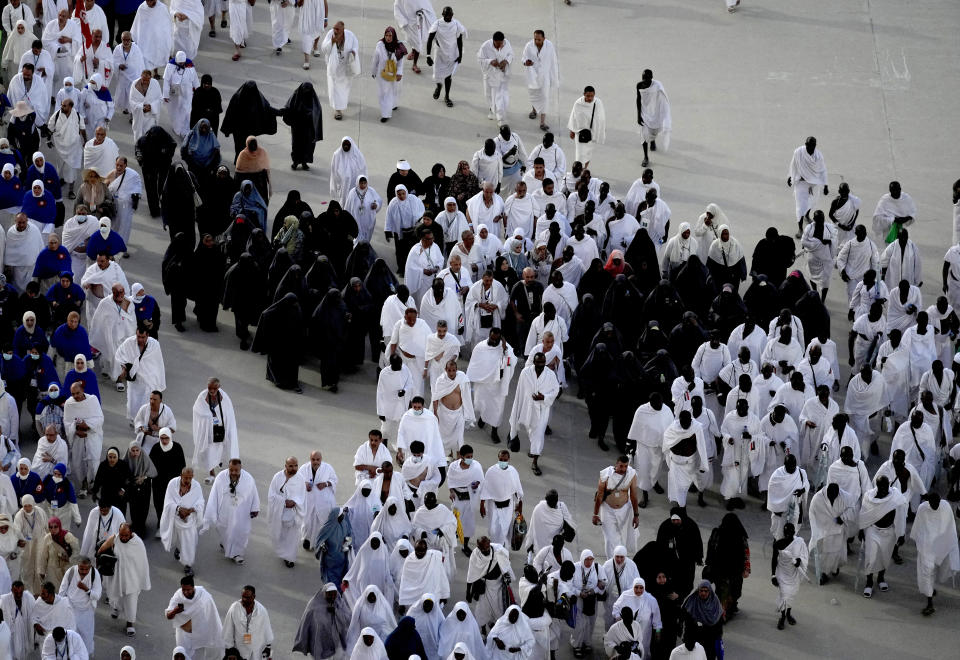 Muslim pilgrims walk to cast stones at a pillar in the symbolic stoning of the devil, during the last rite of the annual hajj, and the first day of Eid al-Adha, in Mina near the city of Mecca, Saudi Arabia, Saturday, July 9, 2022. (AP Photo/Amr Nabil)