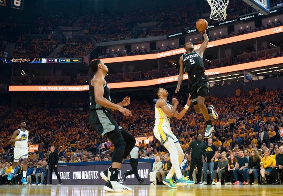 Sacramento Kings guard De’Aaron Fox (5) dunks the ball defended by Golden State Warriors guard Jordan Poole (3) during Game 4 of the first-round NBA playoff series at Chase Center in San Francisco on Sunday, April 23, 2023.