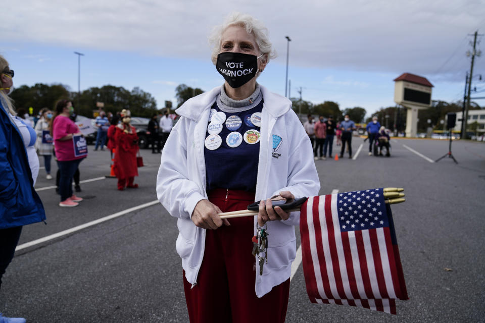 FILE - In this Nov. 15, 2020, file photo a supporter waits to hear Georgia Democratic candidate for U.S. Senate Jon Ossoff and Raphael Warnock speak during a rally in Marietta, Ga. (AP Photo/Brynn Anderson, File)