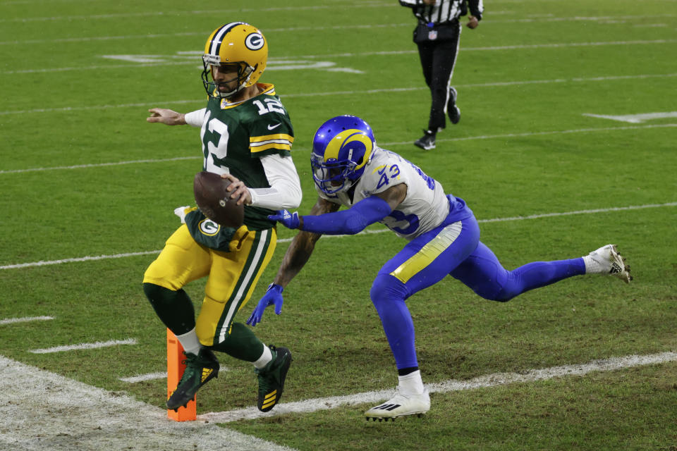 Green Bay Packers quarterback Aaron Rodgers scores on a one-yard touchdown run past Los Angeles Rams' John Johnson during the first half of an NFL divisional playoff football game, Saturday, Jan. 16, 2021, in Green Bay, Wis. (AP Photo/Matt Ludtke)