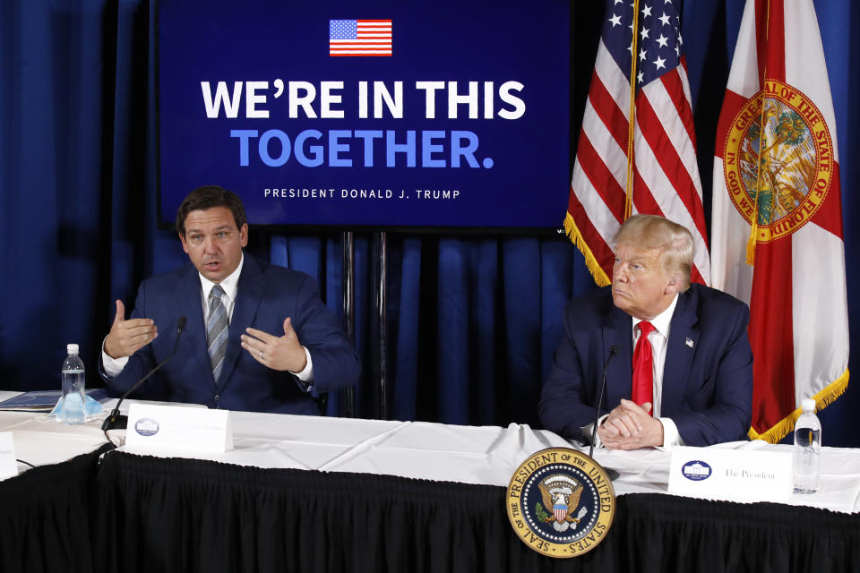 Florida Gov. Ron DeSantis, left, speaks alongside President Donald Trump during a July roundtable discussion.