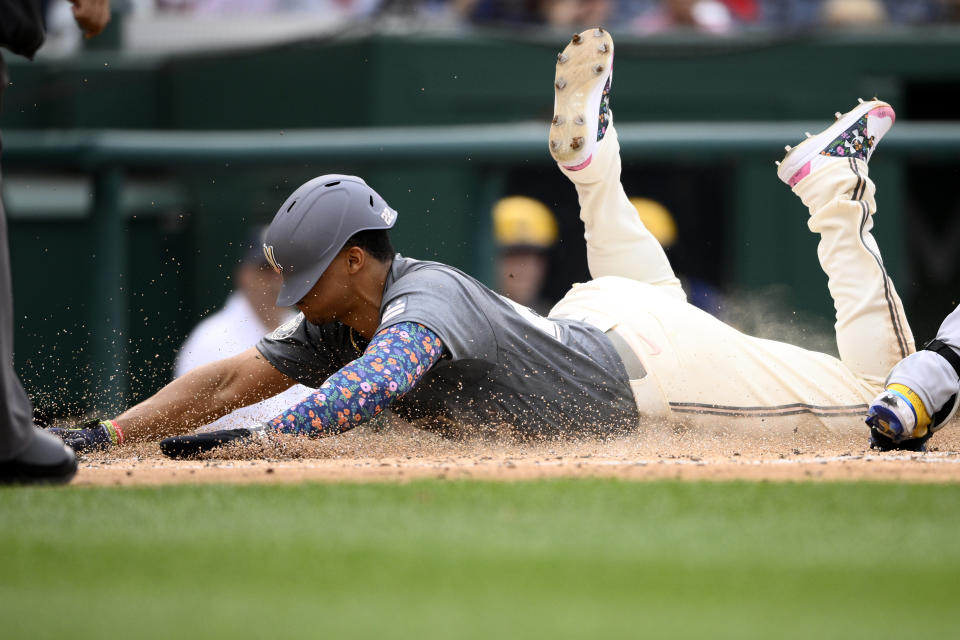 Washington Nationals' Juan Soto slides home as he scores on a sacrifice fly by Josh Bell during the third inning of a baseball game against the Milwaukee Brewers, Saturday, June 11, 2022, in Washington. (AP Photo/Nick Wass)