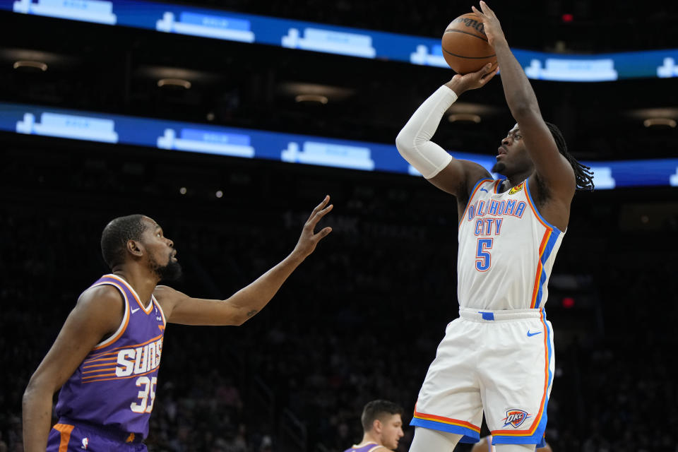 Oklahoma City Thunder guard Luguentz Dort shoots in front of Phoenix Suns forward Kevin Durant (35) during the first half of an NBA basketball game, Sunday, March 3, 2024, in Phoenix. (AP Photo/Rick Scuteri)