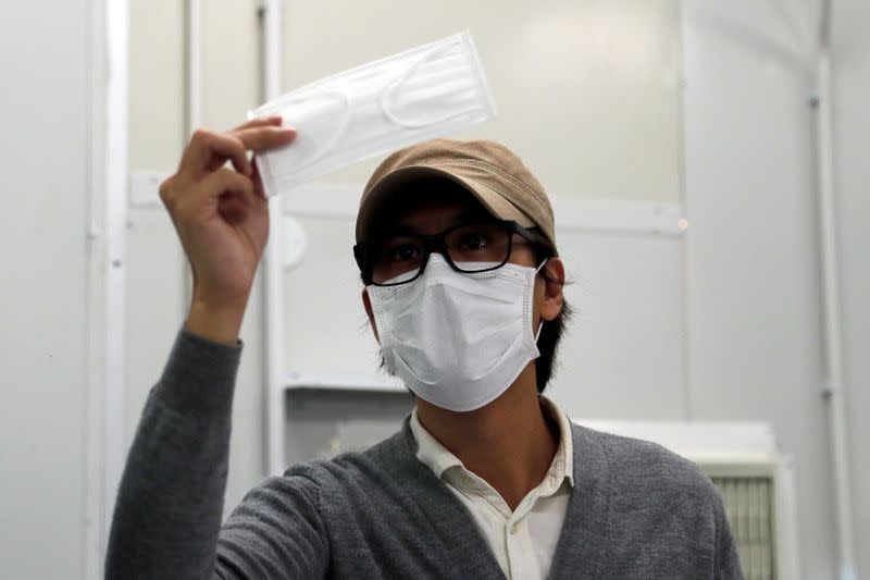 Mask Factory founder Mr. Tang, checks a prototype face mask at his factory, following the outbreak of the new coronavirus, in Hong Kong