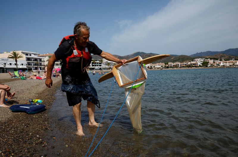 Un voluntario retira una red de arrastre del mar durante un proyecto de investigación "Surfing for Science" de la Universidad de Barcelona para evaluar la contaminación por microplásticos en el litoral, en Llanca, cerca de Figueres, España