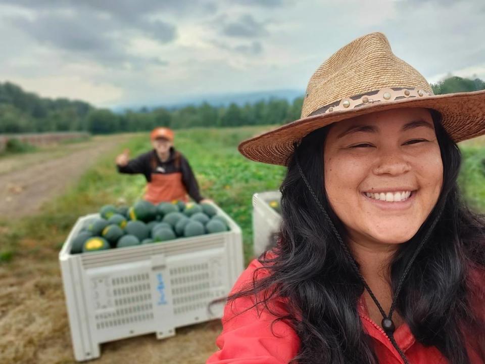 Savannah Flynn takes a selfie with another farmer and her crops grown on farmland in Everson, Wash.